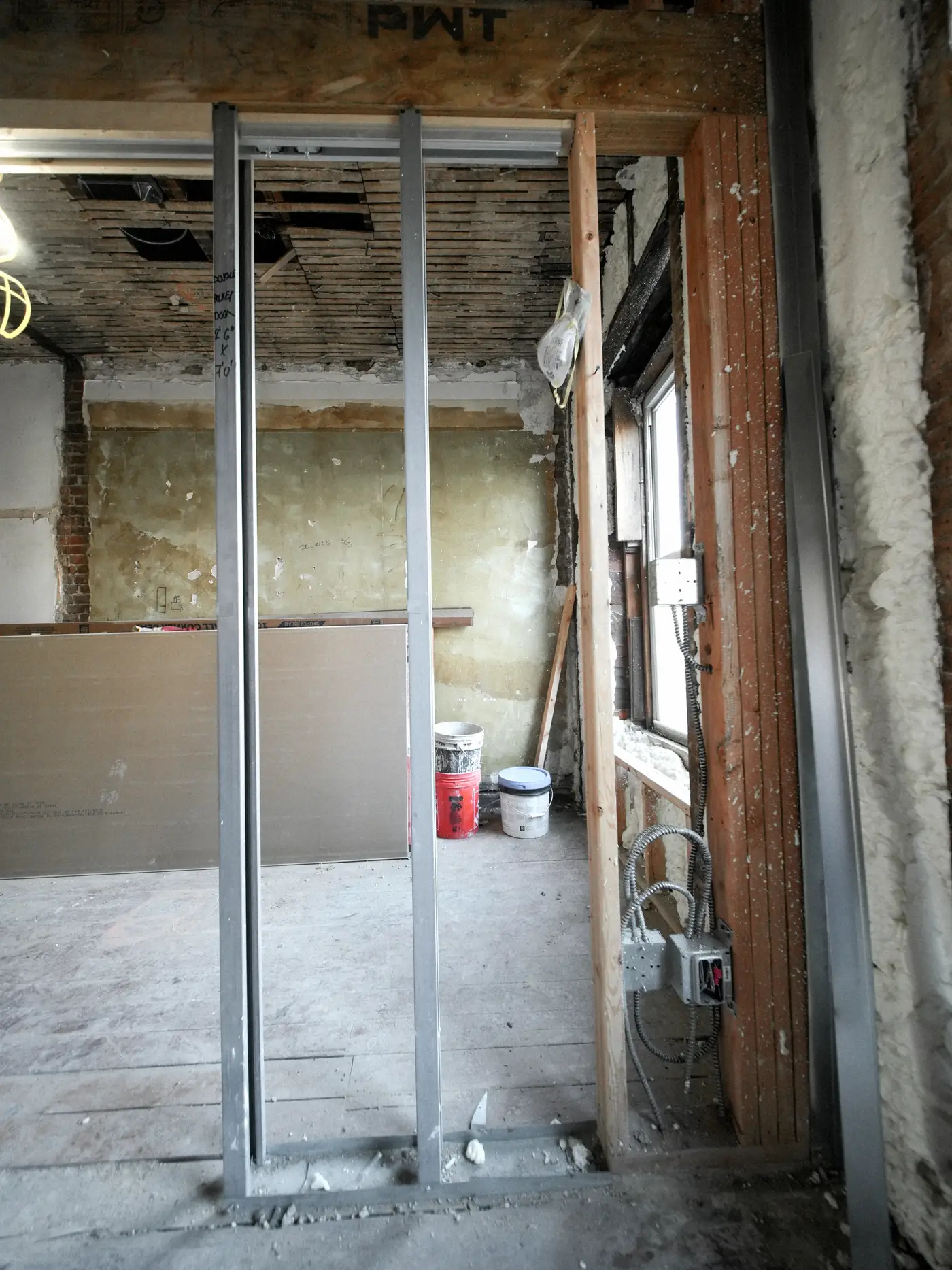 Cloison en cours de montage : montants métalliques, laine minérale et plaques de plâtre